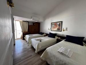 um quarto de hotel com três camas e uma janela em Hotel Aiello em San Luis mais 48 fotografias