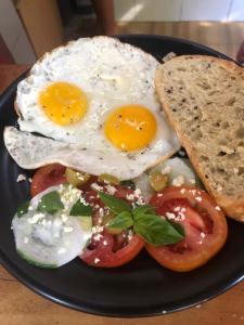 un plato de huevos, tomates y pan en una mesa en La Bohème, en Gili Air