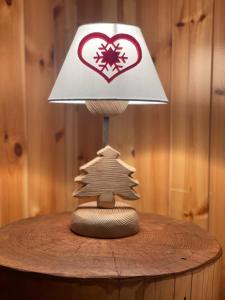 a lamp on top of a table with a christmas tree at Case Vacanza Perron in Sauze dʼOulx
