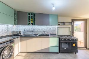 a kitchen with a stove and a washer and dryer at Serenada 2BR Apartment In Batroun in Batroûn
