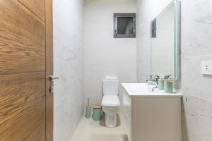 a bathroom with a toilet and a sink and a mirror at Serenada 2BR Apartment In Batroun in Batroûn +18 photos