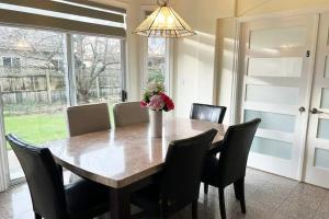 a dining room table with chairs and a vase with flowers at Private 2BR, 1BA with shared Kitchen in a House, Free Parking, 15 Min YVR in Richmond
