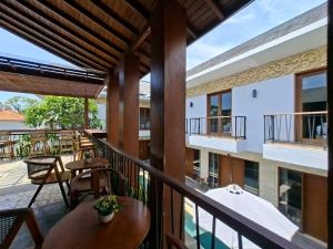 a balcony of a building with tables and chairs at Mahesa Seminyak in Seminyak