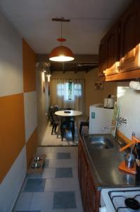 a kitchen with a sink and a table with chairs at Con alma de Paraná, patio y estacionamiento propio in Paraná