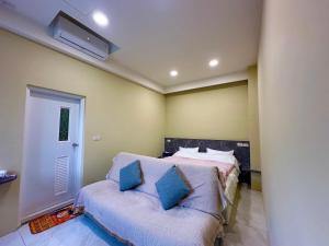 Un dormitorio con una cama con almohadas azules. en 草莓驛站, en Dahu