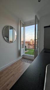 a living room with a mirror and a large window at Evasion romantique à Vichy in Vichy +4 photos