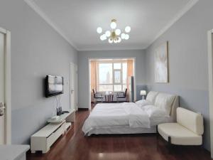 ハルビン市にあるCentral Street River View Apartmentのベッドルーム(白いベッド1台付)、リビングルームが備わります。