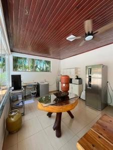 uma cozinha com uma mesa e um frigorífico de aço inoxidável em Casa Aconchego Fóz em Foz do Iguaçu