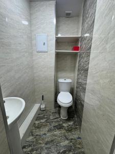 a bathroom with a toilet and a sink at Уютный Апартамент Новостройка 舒适公寓 in Tashkent