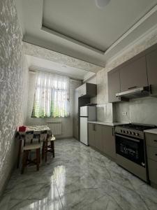 a kitchen with a table and a dining room at Уютный Апартамент Новостройка 舒适公寓 in Tashkent
