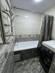 a bathroom with a tub and a sink and a shower at Уютный Апартамент Новостройка 舒适公寓 in Tashkent