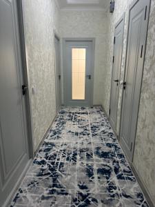 a hallway with a blue and white tile floor at Уютный Апартамент Новостройка 舒适公寓 in Tashkent