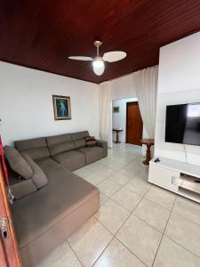 uma sala de estar com um sofá e uma TV de tela plana em Casa Aconchego Fóz em Foz do Iguaçu