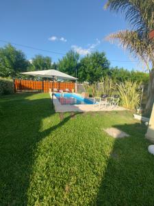 einen Pool im Garten mit Sonnenschirm in der Unterkunft Quinta la hermosa in Villa María