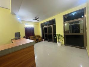 una sala de estar con un escritorio y una sala de estar con en Rinchen Stay Bodhgaya, en Bodh Gaya 10 fotos más