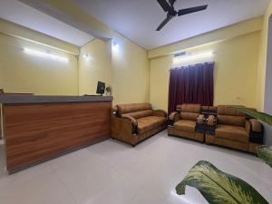 Una sala de espera con dos sillas de cuero y un podio. en Rinchen Stay Bodhgaya, en Bodh Gaya