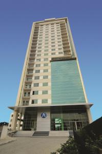 Un edificio alto con una señal azul. en Affinity Aparta Hotel, en Medellín