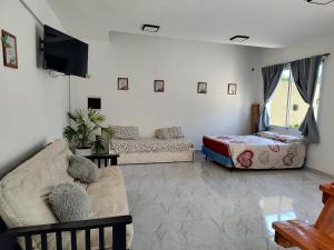 ein Wohnzimmer mit einer Couch und einem Bett in der Unterkunft Quinta la hermosa in Villa María