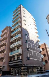 un grand bâtiment avec des fenêtres sur le côté dans l'établissement KINSHICHO Tokyo Holiday Hotel, à Tokyo