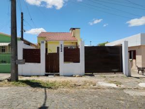 a yellow and white house with a gate at POUSADA TEMPORADA BIBi casa inteira com café in São Gabriel