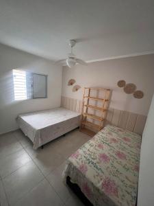 Un dormitorio con 2 camas y una escalera. en Casa Aconchegante em Itanhaem- Piscina e Churrasqueira 10 pessoas, en Itanhaém 23 fotos más