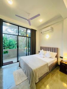 a bedroom with a bed with a ceiling fan at Tropictide Weligama in Weligama