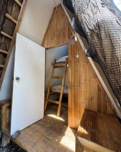 a ladder sitting inside of a small house at San Juan ELYU Beachfront Cabin in San Juan