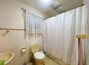 a bathroom with a toilet and a shower curtain at Casa con Jardín in Cochabamba