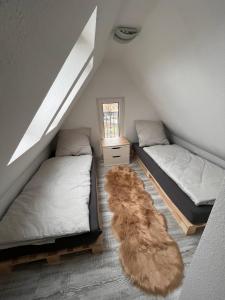 Schlafzimmer im Dachgeschoss mit 2 Betten und einem Teppich in der Unterkunft Romantische Ferienwohnung für 5 mit Hund im Erzgebirge in Beierfeld