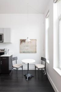 Una cocina blanca con una mesa y dos sillas. en Modern 1BR Apt with Skywalk to Fiserv, Rooftop, and Parking, en Milwaukee