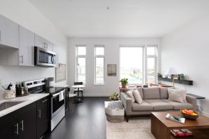 Una cocina y una sala de estar con un sofá y una mesa. en Modern 1BR Apt with Skywalk to Fiserv, Rooftop, and Parking, en Milwaukee