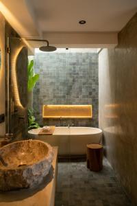 een badkamer met een groot bad en een wastafel bij Sava Villa Ubud Rice Fields View in Tegalalang