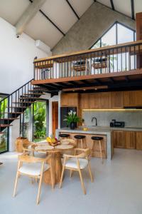 een keuken met een houten tafel en stoelen en een trap bij Sava Villa Ubud Rice Fields View in Tegalalang