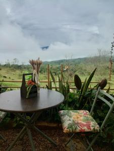 ein Tisch und Stühle mit Blick auf ein Feld in der Unterkunft Cabaña Amanecer in Icononzo