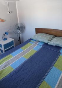 una camera con letto e trapunta blu e verde di Casa interior 2 pisos, 3 hab, 1 cama 2 plazas, 3 camas 1 plaza y 1 litera a Laja