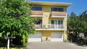 a yellow building with a balcony and two garage at Capitol Retreats-Views! Near Salt Palace,Sleep 28 in Garden Towers Condominium