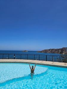 una donna in piedi in acqua in una piscina di El Peñon-Rodadero-Sunset-Cheap Building a Rodadero