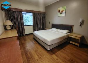 um quarto de hotel com uma cama e uma janela em Cameron Highlands homestay em Brinchang