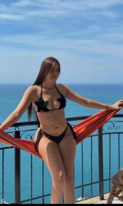 Una donna in bikini in piedi su una ringhiera di El Peñon-Rodadero-Sunset-Cheap Building a Rodadero