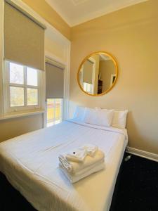 a bedroom with a white bed with a mirror at Gardners Inn Hotel in Blackheath +58 photos
