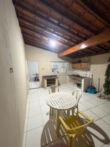 a table and chairs in a room with a kitchen at Pousada cosmo in Uberaba
