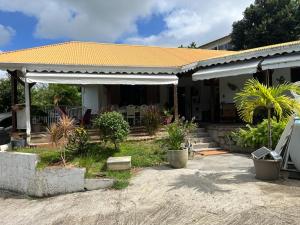 a house with a porch with a roof at Villa F3, Eden Krys, a cocoon of tranquility in La Trinité