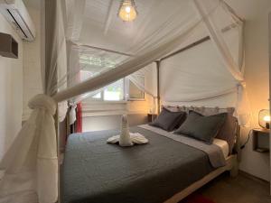 a bedroom with a canopy bed and a window at Villa F3, Eden Krys, a cocoon of tranquility in La Trinité +60 photos