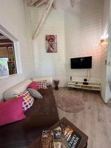 a living room with a couch and a flat screen tv at Villa F3, Eden Krys, a cocoon of tranquility in La Trinité