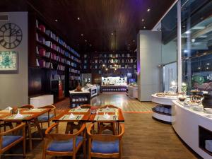 a restaurant with tables and chairs and a counter at Mercure Jakarta Simatupang in Jakarta