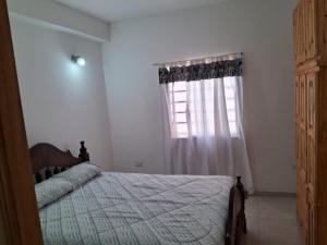 ein Schlafzimmer mit einem Bett und einem Fenster in der Unterkunft Casa mar del tuyu in Mar del Tuyú + 7 Fotos