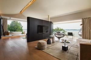 sala de estar con sofá, TV y ventana grande en Floral Luxury Wuhu Lake Art Hotel, en Wuhu