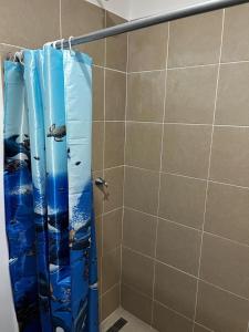 una doccia con una tenda da doccia blu in un bagno di Casa moderna en urbanización privada a Manta