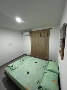 una piccola camera con un letto verde di Casa moderna en urbanización privada a Manta