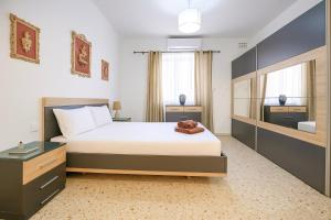 Un dormitorio con una cama grande y un espejo. en Gżira Well-Equipped 4BR Flat in Peaceful - GV, en Il-Gżira
